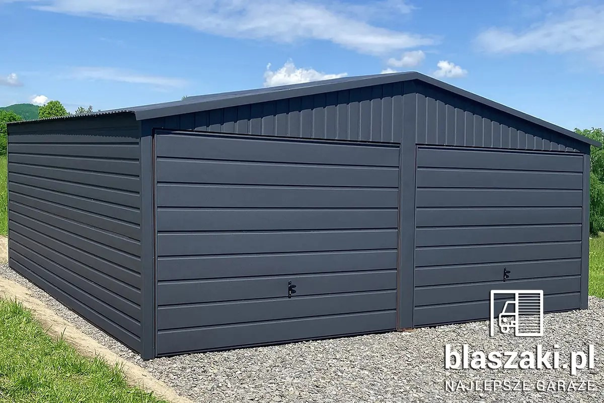 Grafitowy garaż blaszany dwustanowiskowy z poziomym panelem, na żwirowym podłożu, z logo firmy w prawym dolnym rogu, na tle zieleni i błękitnego nieba.