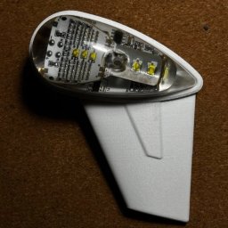 4AirSafe sp. z o.o. - Prototyp lampy stroboskopowej do samolotu. Obudowa biała, wykonana z tworzywa, przezroczysta góra odsłania płytkę PCB z diodami LED. Widoczne elementy elektroniczne.