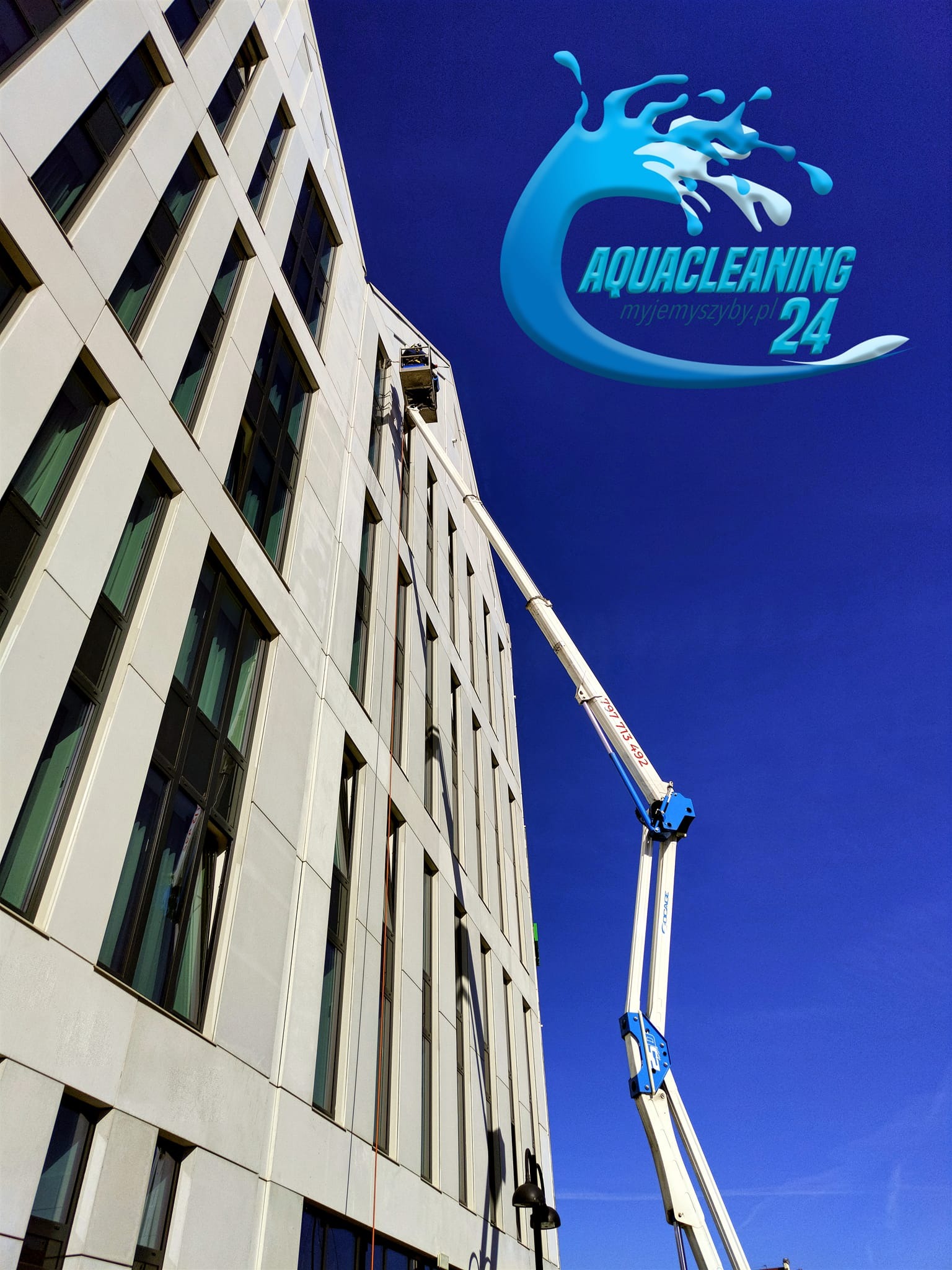Wysokopodnośnik z pracownikiem przy elewacji budynku podczas mycia okien. Logo firmy Aquacleaning w prawym górnym rogu. Błękitne niebo w tle.