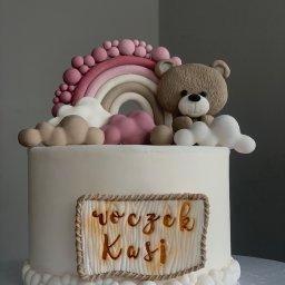 Kruche inspiracje - Tort urodzinowy dla Kasi z dekoracją: tęcza, chmurki i miś. Kremowy tort z napisem na drewnianej tabliczce, pastelowe kolory, ręcznie robione dekoracje.