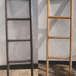 ELASER - Drabina dekoracyjna po renowacji: po lewej surowa, ciemna rama, po prawej odnowiona, jasna rama z widocznym usłojeniem drewna na tle ściany o fakturze baranka.