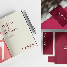 Miodove Design - Zestaw materiałów identyfikacji wizualnej marki Luminosa: notatnik z hasłem, wizytówka, voucher, teczka i mockup telefonu, wszystko w odcieniach bordo i bieli, z kwiatami magnolii.