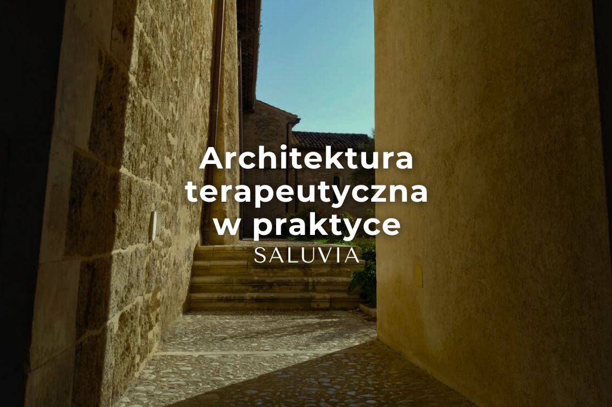 Ujęcie wąskiego przejścia z kamiennymi ścianami i schodami, z tekstem 'Architektura terapeutyczna w praktyce SALUVIA' nałożonym na obraz.