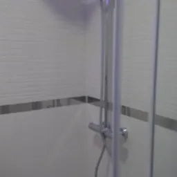 Nowoczesna kabina prysznicowa z deszczownicą i słuchawką, białe płytki z poziomym wzorem i srebrnym paskiem, oświetlenie LED w kolorze fioletowym u góry.