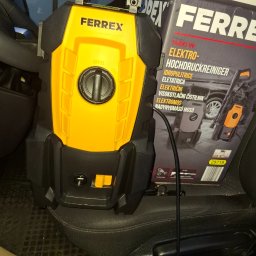 Szymon Kołecki - Elektryczna myjka ciśnieniowa Ferrex 1400W, obok pudełko z tym samym modelem, leżąca na siedzeniu pojazdu. Sprzęt do czyszczenia powierzchni.