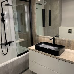 LukasFliz - Nowoczesna łazienka w Raba Wyżna z czarną armaturą i umywalką nablatową. Kabina prysznicowa ze szklaną ścianką i grafitowymi profilami. Minimalistyczny design.