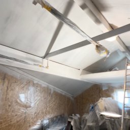 SPONTANDEKOR Tomasz Antoniewicz - Białe malowanie poddasza z drewnianą boazerią zabezpieczoną folią. Widoczne elementy konstrukcyjne dachu i drabina. Prace malarskie w toku, zabezpieczenie przed zabrudzeniem.