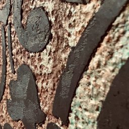 SPONTANDEKOR Tomasz Antoniewicz - Dekoracyjna faktura ściany z ciemnymi, wypukłymi wzorami na tle w odcieniach brązu i zieleni, wykonana techniką malarską z efektem trójwymiarowości.