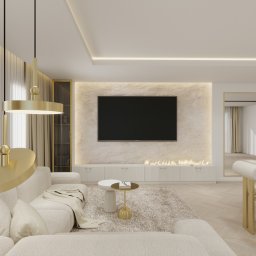 Lumi Interior - Elegancki salon w beżach: sofa z poduszkami, stolik kawowy, TV na ścianie z efektem kamienia, kominek, złote lampy i detale. Nowoczesne wnętrze z lustrem.