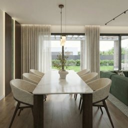 M2 Projekt - Nowoczesna jadalnia z marmurowym stołem, krzesłami z beżową tapicerką i widokiem na ogród przez duże okna. Minimalistyczna lampa wisząca nad stołem.