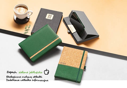 Kalendarze książkowe z ekoskóry na rok 2026 w różnych kolorach i fakturach, prezentowane w Tychach, obok filiżanki kawy i spinaczy.