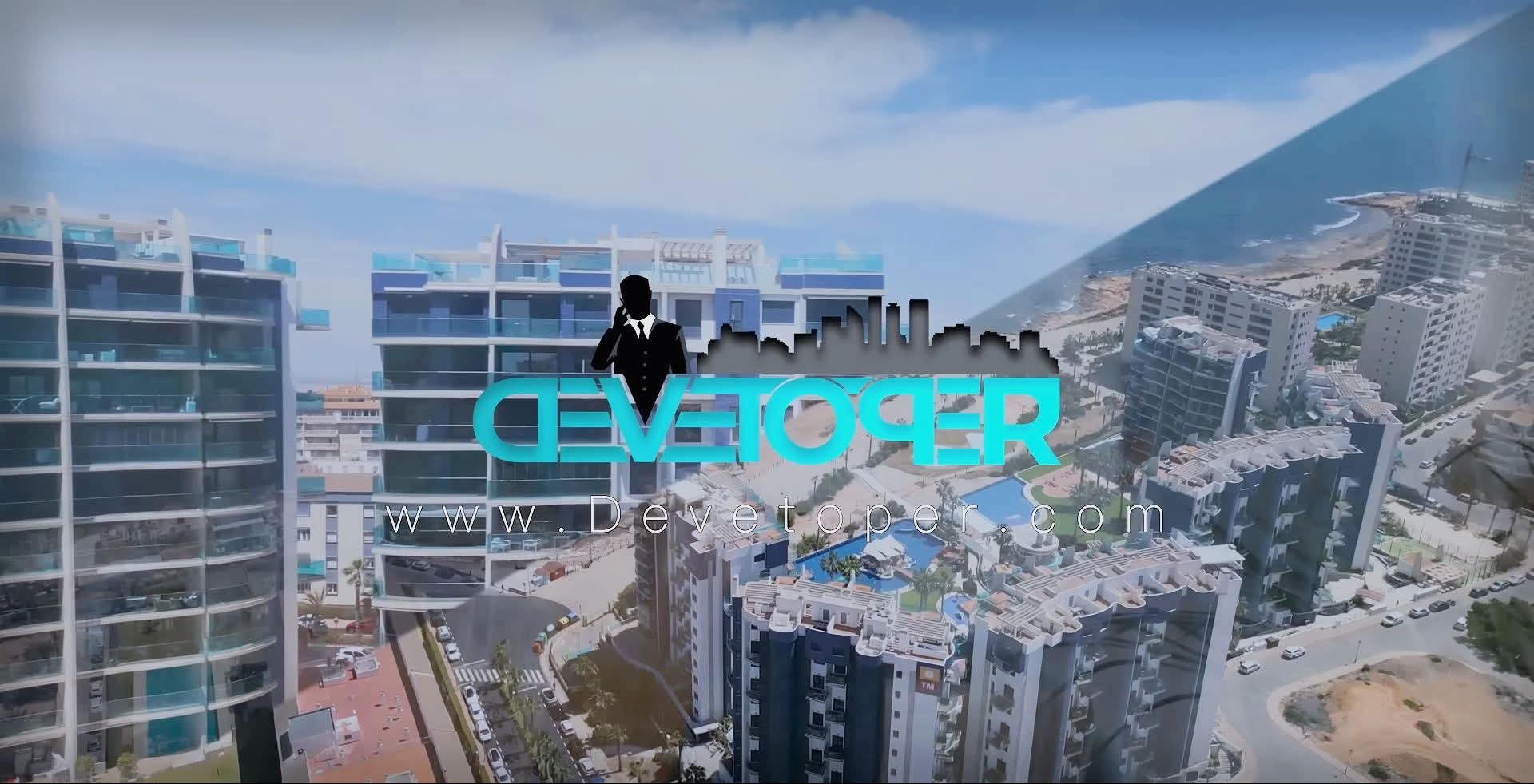 Nowoczesne apartamenty z basenami, widok z lotu ptaka, logo dewelopera na pierwszym planie, błękitne niebo i morze w tle. Unikalny kadr z perspektywy.