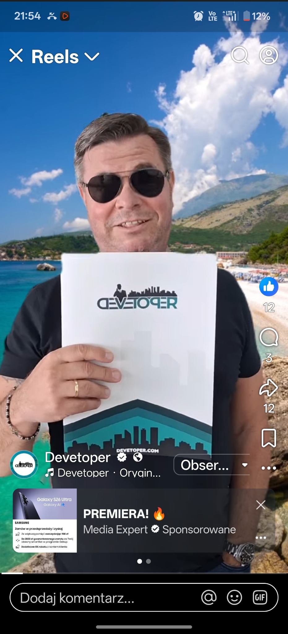 Mężczyzna w okularach słonecznych prezentuje logo firmy deweloperskiej na tle plaży. Logo zawiera sylwetkę miasta i napis 'DEVETOPER'.