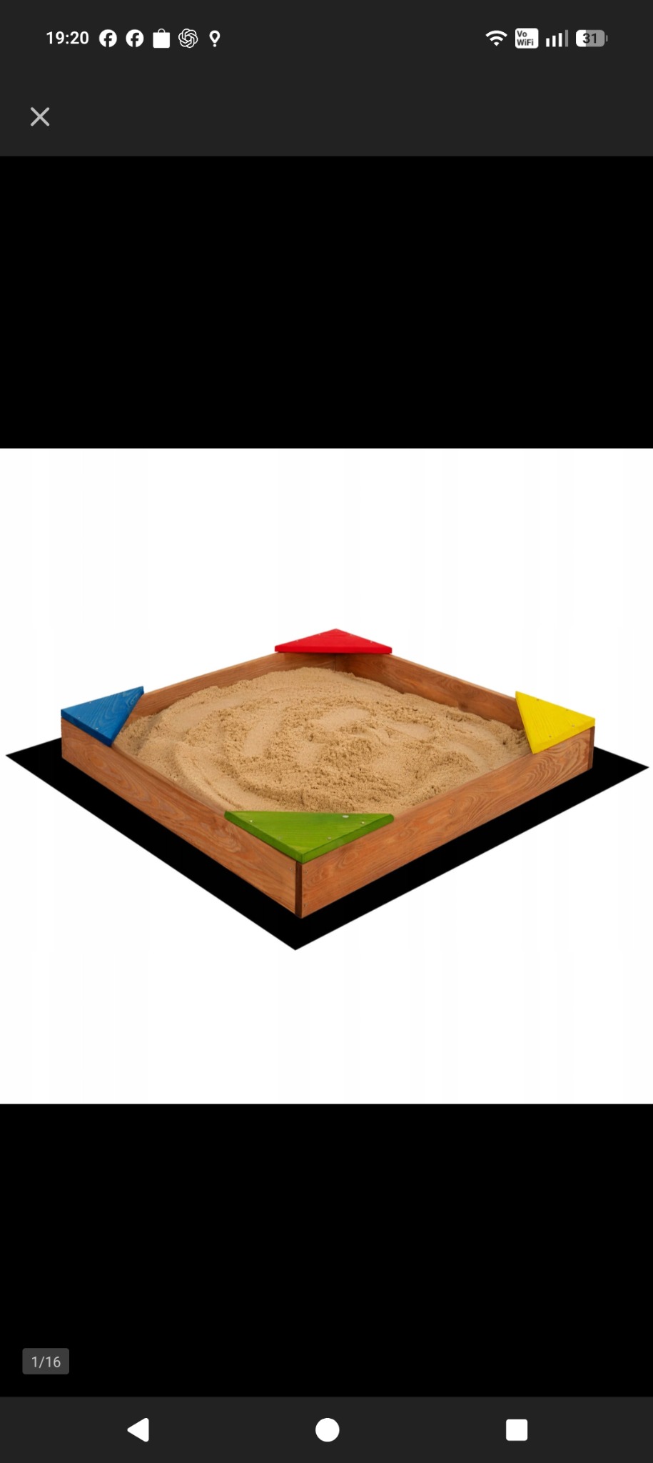 Drewniana piaskownica z kolorowymi narożnikami (czerwony, żółty, zielony, niebieski) wypełniona piaskiem, umieszczona na czarnej macie. Widok z góry.