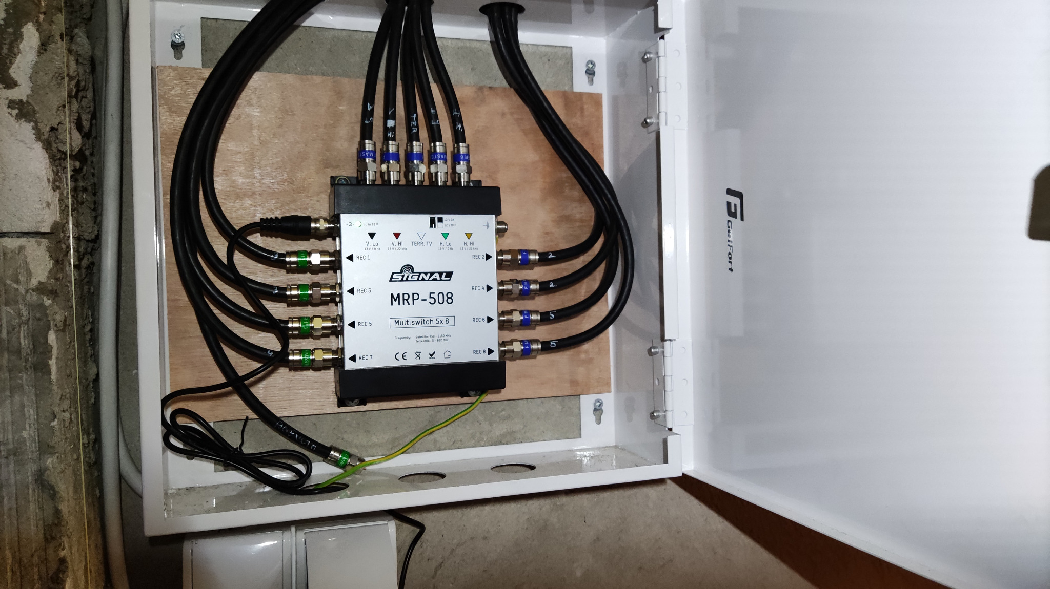 Rozdzielacz antenowy Signal MRP-508 w białej skrzynce, z podłączonymi kablami koncentrycznymi. Widoczne złącza i oznaczenia REC 1-8. Instalacja wewnątrz budynku.