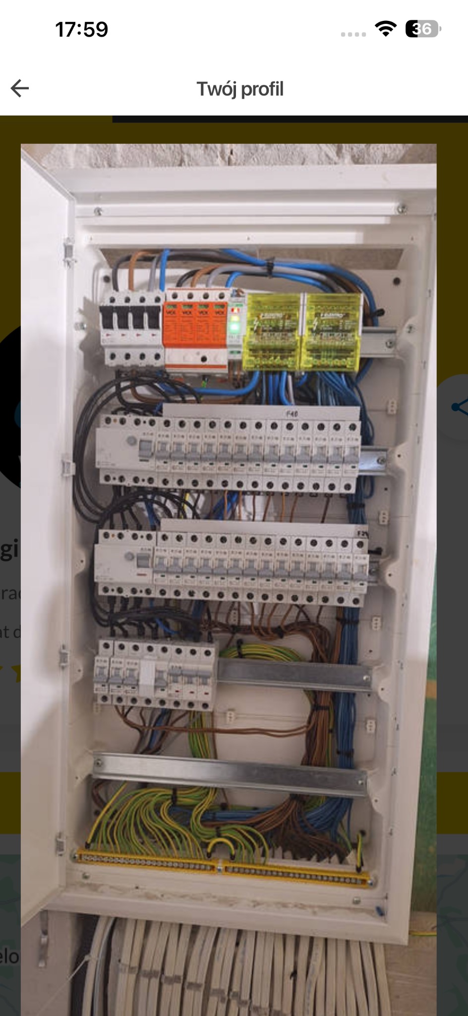 Rozdzielnia elektryczna w białej obudowie, widoczne zabezpieczenia, przewody w różnych kolorach, listwa zaciskowa. Instalacja po montażu, gotowa do użytku.