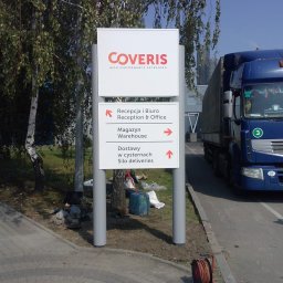 SCAN MOTOPOL SPÓŁKA Z OGRANICZONĄ ODPOWIEDZIALNOŚCIĄ - Tablica informacyjna z logo Coveris, strzałkami kierunkowymi do recepcji, magazynu i dostaw w cysternach, umieszczona na zewnątrz budynku, obok zaparkowanej ciężarówki.