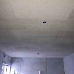 MAM Remonty - Sufit z płyt kartonowo-gipsowych w surowym wnętrzu, widoczne łączenia płyt i otwór na instalację elektryczną. Ściany z białego bloczka.