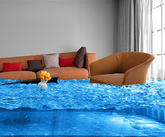 Zalane wnętrze: brązowa sofa z poduszkami, fotel i wazon z żółtymi kwiatami w wodzie. Widoczne ślady zalania, jasne światło wpadające przez okno.