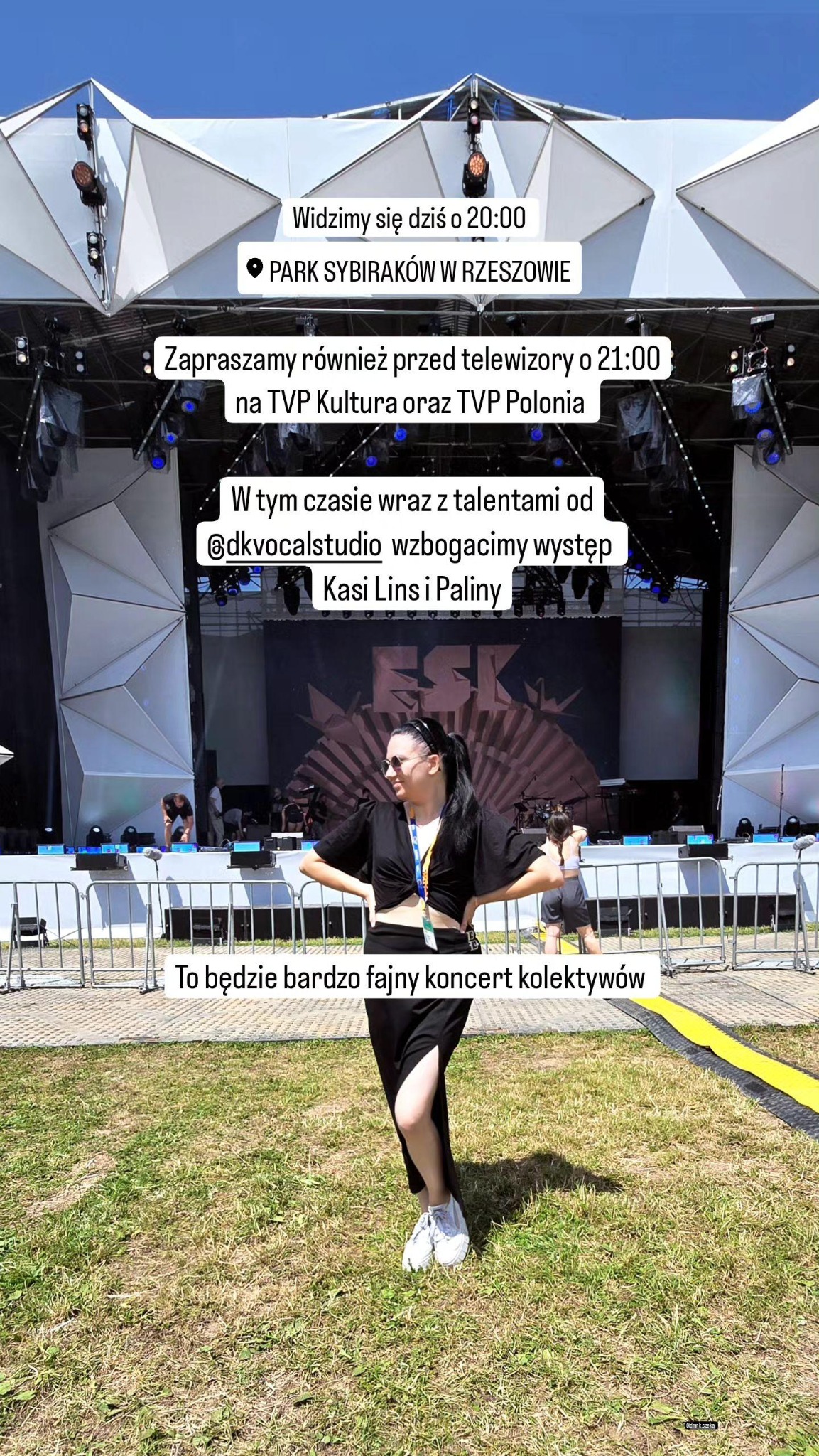 Piosenkarka w czarnym stroju pozuje na tle sceny przed koncertem plenerowym w Parku Sybiraków w Rzeszowie. Na scenie widoczny napis ESK.