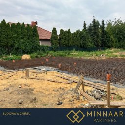 MINNAAR PARTNERS SPÓŁKA Z OGRANICZONĄ ODPOWIEDZIALNOŚCIĄ - Zbrojenie fundamentów pod budowę domu jednorodzinnego w Gliwicach. Widoczne siatki zbrojeniowe i rury kanalizacyjne na przygotowanym terenie.