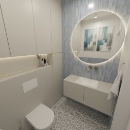 SPACE CONCEPT- PROJEKTOWANIE WNĘTRZ JOANNA MACIEJEWSKA - Nowoczesna łazienka z okrągłym lustrem podświetlanym LED, umywalką w szafce i toaletą. Błękitne płytki na ścianie i wzorzysta podłoga. Minimalistyczny design.