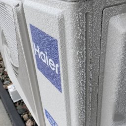 Wentica Tomasz Manowski - Zaszroniony agregat klimatyzacji Haier w Pruszczu Gdańskim. Widoczne kryształki lodu na obudowie i logo. Niska temperatura otoczenia.