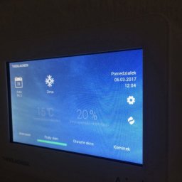 Wentica Tomasz Manowski - Ekran sterownika rekuperacji THESSLAGREEN z ustawieniami: tryb zima, temperatura 15°C, intensywność wentylacji 20%, data 06.03.2017, opcje: wietrzenie, pusty dom, otwarte okno, kominek.