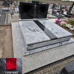 Kamieniarstwo Artystyczne Jacek Kociołek - Granitowy nagrobek z czarnymi tablicami i krzyżem na cmentarzu, widok z boku, z logo firmy kamieniarskiej w rogu. Szara kolorystyka, pochmurne niebo w tle.
