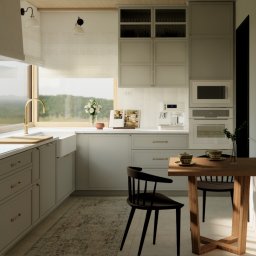 Materna Design - Jasna kuchnia w stylu skandynawskim z drewnianym stołem i czarnymi krzesłami. Widok na zieleń za oknem. Uwagę przyciąga złota bateria przy zlewie.