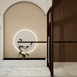 Materna Design - Minimalistyczne wnętrze z dekoracyjnym drzewkiem bonsai w okrągłej, podświetlanej niszy. Marmurowa podłoga i drewniane panele ścienne tworzą elegancki kontrast.