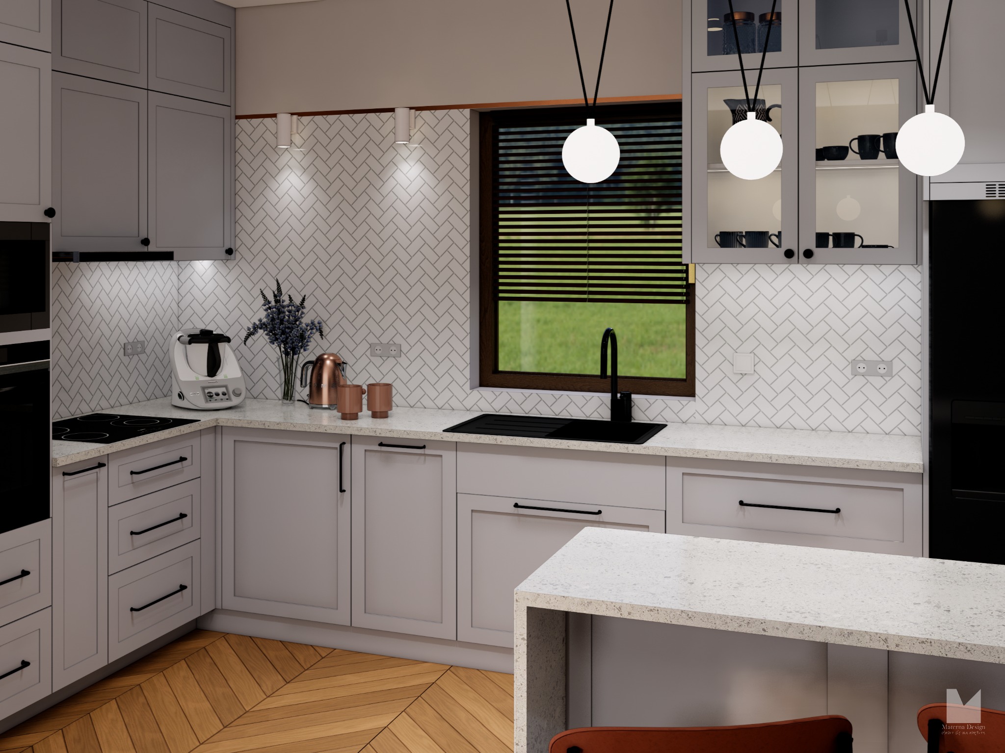 Jasna kuchnia z szarymi szafkami, białym blatem i drewnianą podłogą w jodełkę. Nad blatem wiszą trzy okrągłe lampy. Widok na okno z żaluzjami i zielenią na zewnątrz.