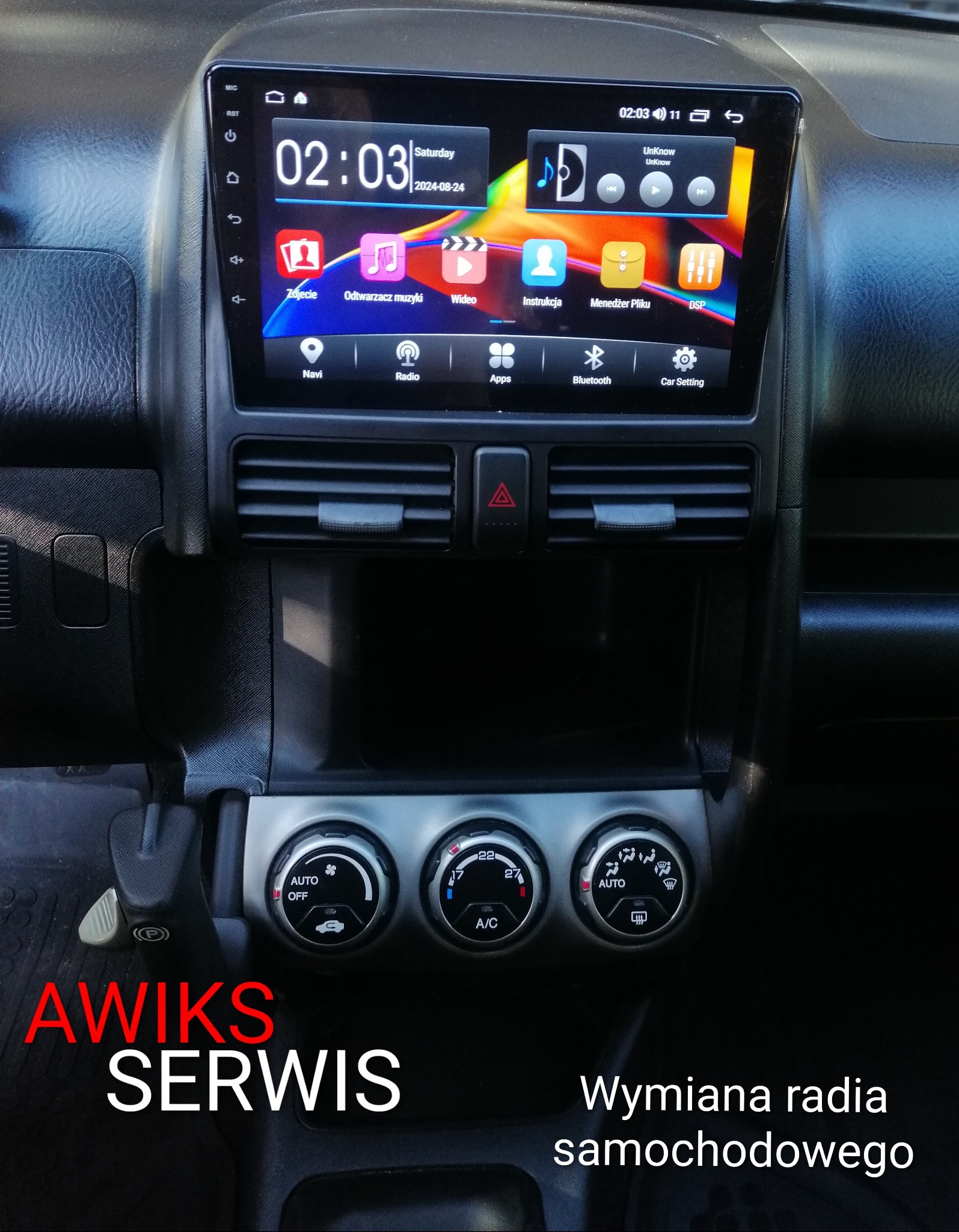 Wymiana radia samochodowego z ekranem dotykowym. Widoczny interfejs Android z ikonami aplikacji. Panel sterowania klimatyzacją. Logo serwisu AWiks.