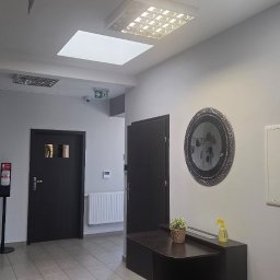 DLF PLACE sp. z o.o. - Wnętrze biura po sprzątaniu: czyste podłogi, zadbane meble, lustro na ścianie, dozownik z płynem dezynfekującym, schludne dekoracje i oświetlenie.