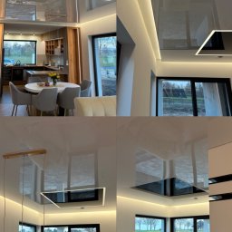 StretchDom-sufity napinane - Nowoczesny salon z błyszczącym sufitem napinanym, oświetleniem LED i dużymi oknami. Widok na zewnątrz z elementami wyposażenia wnętrza.