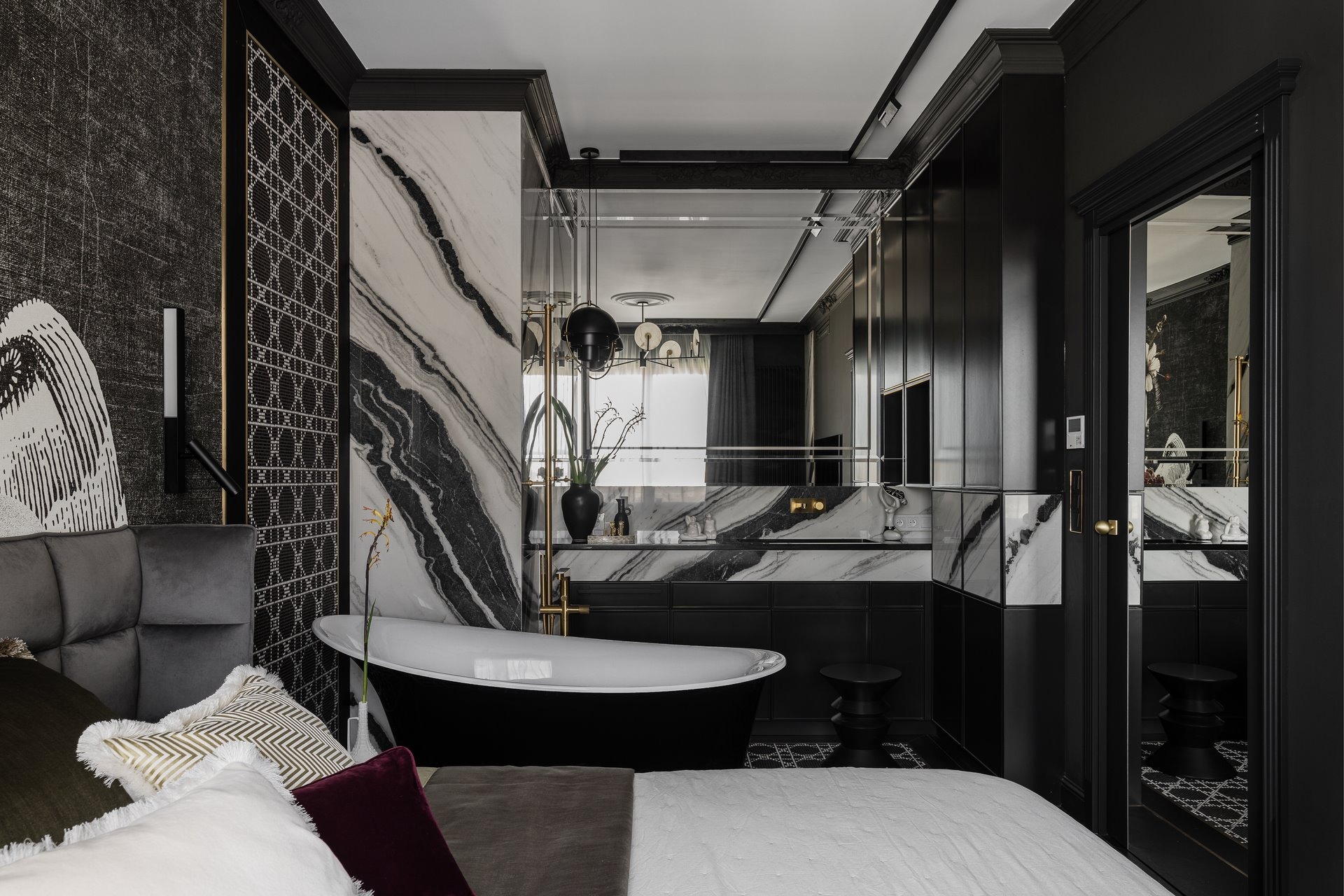 Elegancka sypialnia z wanną wolnostojącą na tle marmurowej ściany i czarnych szafek. Luksusowe wnętrze w stylu glamour z dekoracyjnymi poduszkami i oświetleniem.