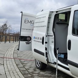 MICHAŁ GRABKA EMG - Biały samochód EMG-energetyka z otwartymi drzwiami, sprzęt pomiarowy w środku, kabel na zewnątrz. Diagnostyka i lokalizacja uszkodzeń kabli SN i NN.