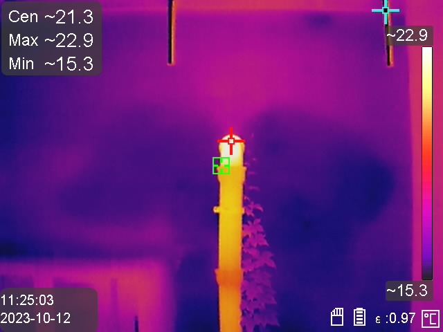 Termowizja pionowej rury, z zaznaczonymi punktami pomiaru temperatury. Widoczne wartości minimalne, maksymalne i centralne temperatury. Data i godzina pomiaru w lewym dolnym rogu.