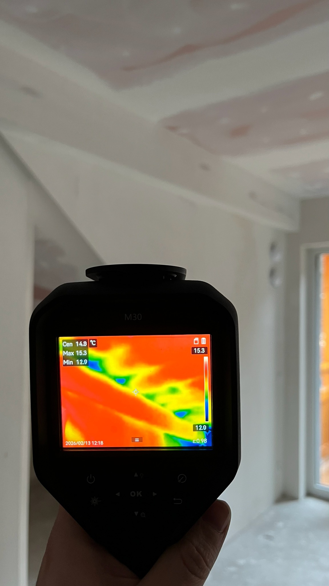 Termowizja sufitu podwieszanego w trakcie prac wykończeniowych, detekcja mostków termicznych. Widoczny ekran kamery termowizyjnej M30 z rozkładem temperatur.