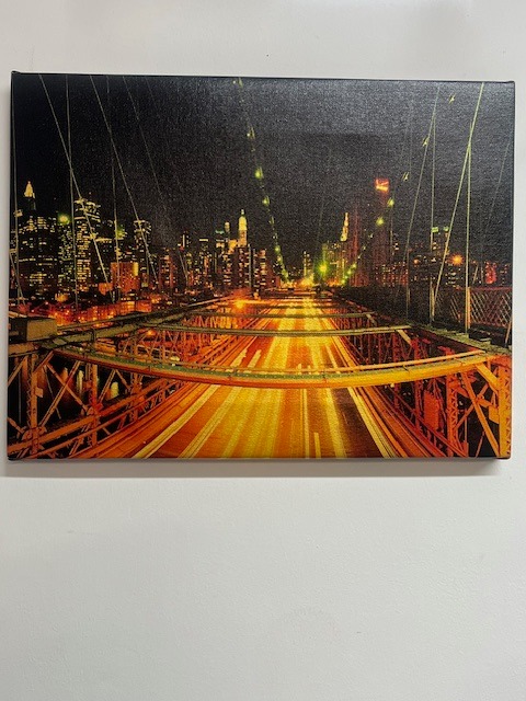 Canvas z nocnym widokiem na miasto i most, z efektem rozmycia świateł. Widoczne detale faktury płótna i krawędzi. Druk na płótnie.