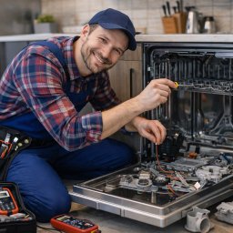 SERWIS AGD - Rafał Sulma - Uśmiechnięty serwisant w kombinezonie i czapce naprawia zmywarkę, używając śrubokręta. Obok skrzynka z narzędziami i miernik. W tle nowoczesna kuchnia.