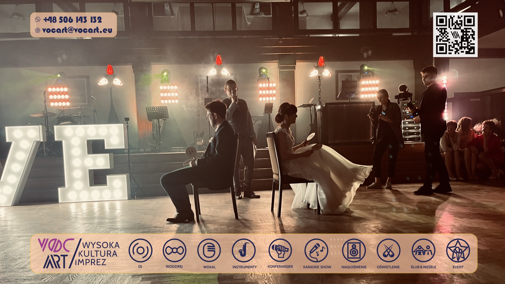 Uroczystość ślubna z podświetlanym napisem LOVE, oświetleniem scenicznym i zespołem muzycznym w tle. Para młoda siedzi na krzesłach, a fotografowie dokumentują wydarzenie.