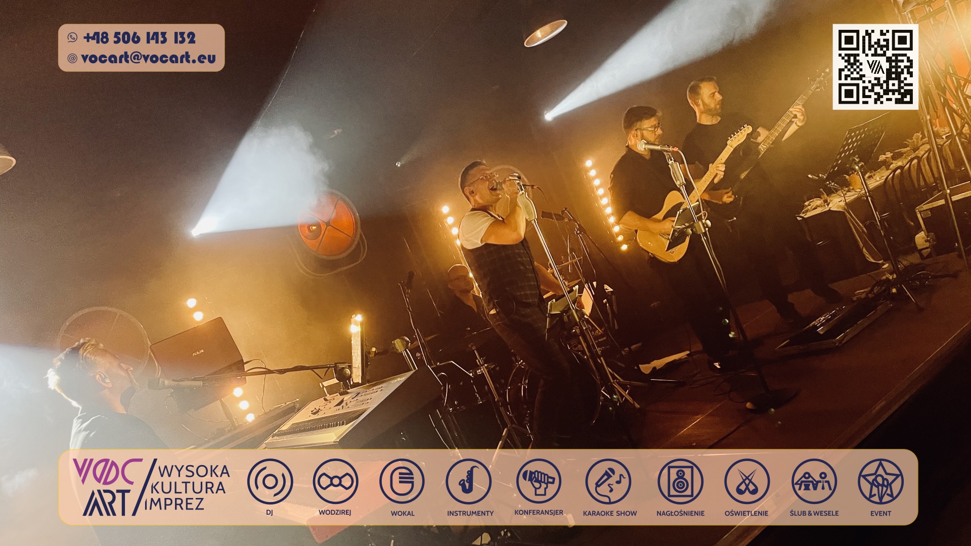 Zespół muzyczny na scenie w trakcie występu. Wokalista śpiewa do mikrofonu, gitarzysta gra na gitarze. Scena oświetlona reflektorami, widoczny sprzęt muzyczny.