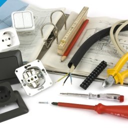 Valentyn Hoidenko - Elementy instalacji elektrycznej: gniazdka, włączniki, przewody, narzędzia, złączki, miernik, schemat instalacji w segregatorze na białym tle.