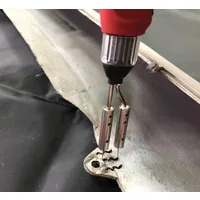 Spawanie plastiku: czerwony pistolet spawalniczy z dwiema dyszami łączy plastikowy element z metalowym uchwytem, tworząc czarne, zygzakowate spoiwo.