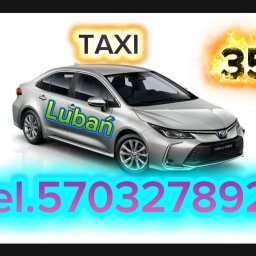 TAXI Lubań 35 - Srebrna Toyota Corolla Hybrid z napisem 'Lubań' i numerem telefonu, stylizowana na taksówkę z płomieniami wokół numeru 35. Reklama usług przewozu.