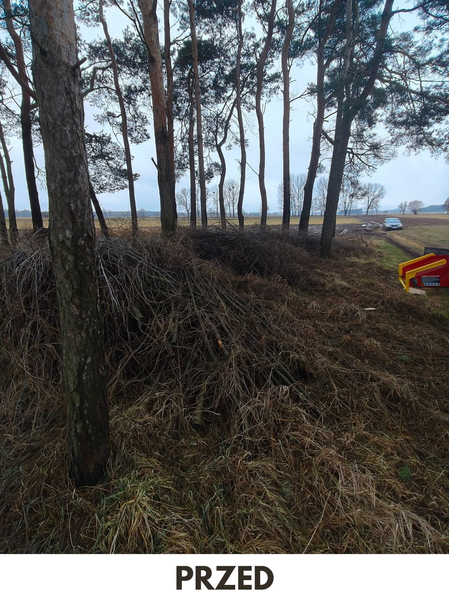 Stos gałęzi i suchych traw pod drzewami na polu, z fragmentem maszyny rolniczej i samochodem w tle. Zdjęcie 'PRZED' sugeruje przygotowanie do prac porządkowych.