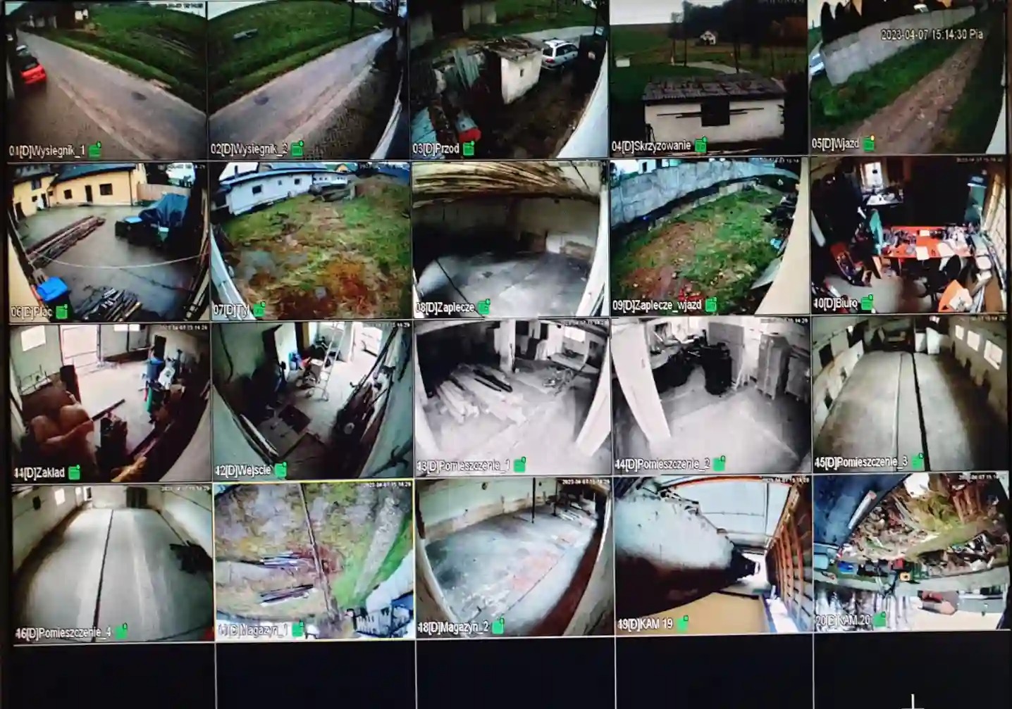 Ekran monitoringu z podglądem z wielu kamer: ulica, podwórko, wnętrza budynków. Widoczne daty i oznaczenia kamer. System monitoringu wizyjnego w akcji.