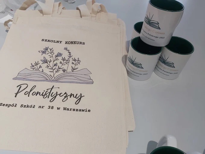 Torby bawełniane i kubki z nadrukiem 'Szkolny Konkurs Polonistyczny' dla Zespołu Szkół nr 38 w Warszawie oraz 'Święto Czytania Polskiego 2022'.