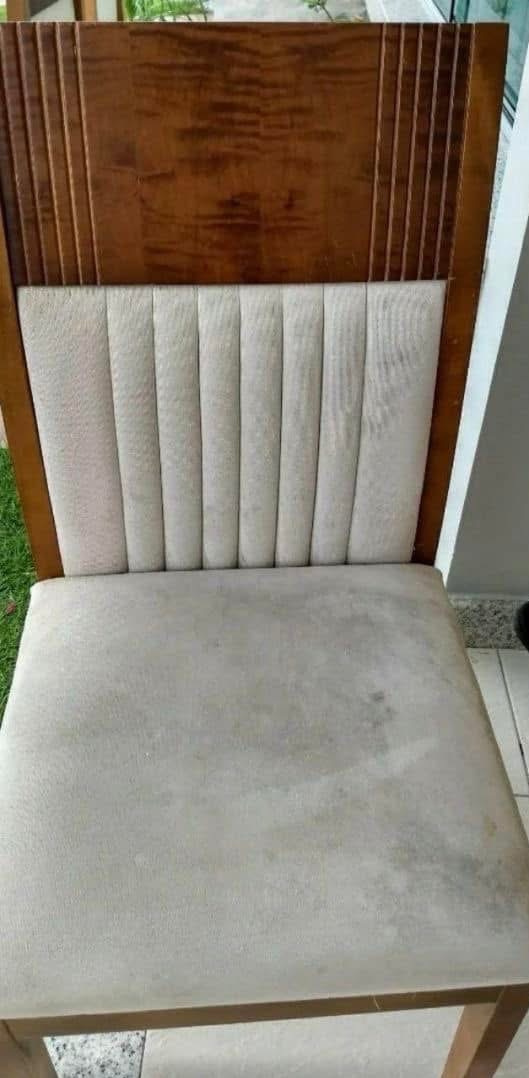 Tapicerowane krzesło z drewnianym oparciem, widoczne plamy na siedzisku, sugerujące potrzebę czyszczenia tapicerki.